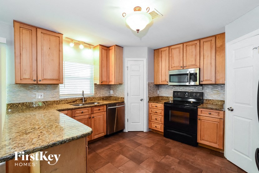 a kitchen with wooden cabinets and granite counter tops