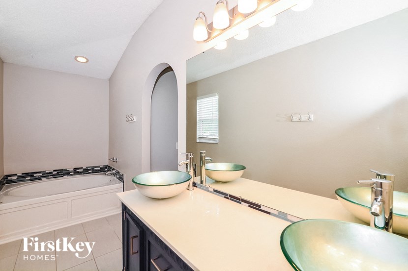 a bathroom with two sinks and a tub and a mirror