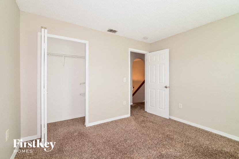 a bedroom with a closet and a door to a hallway