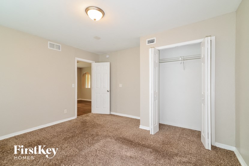 a bedroom with a closet and a door to a hallway
