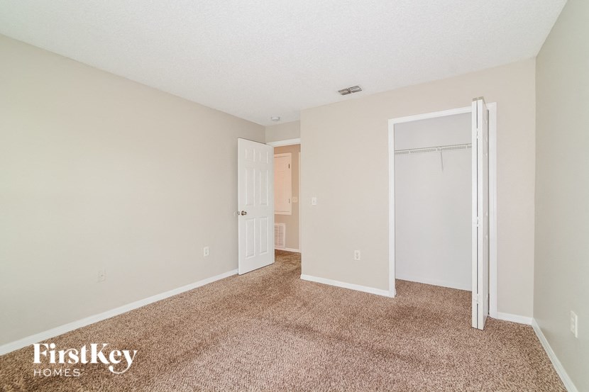a bedroom with a closet and a door to a bathroom