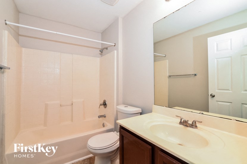 a bathroom with a sink toilet and a mirror