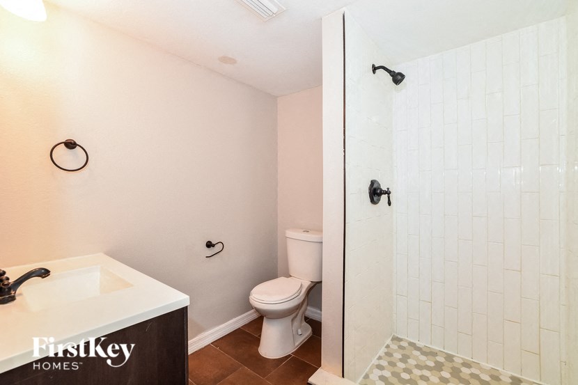 a bathroom with a toilet and a shower and a sink