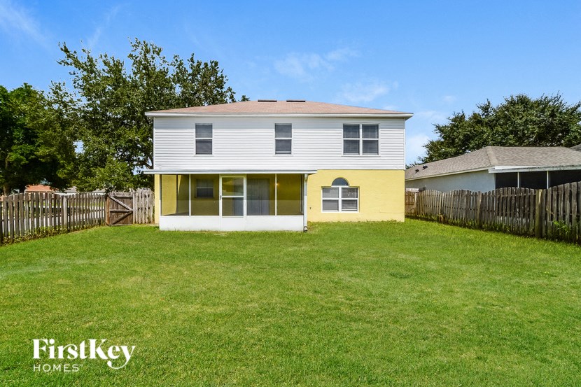 a white and yellow house with a yard and a fence