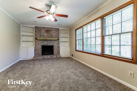 A room with a fireplace and a ceiling fan.