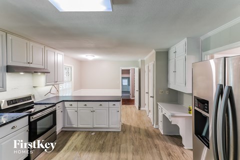 A kitchen with a refrigerator on the right side.