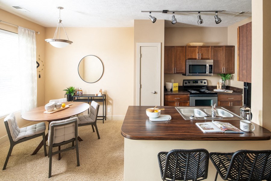 A kitchen with a table and chairs in front of it.