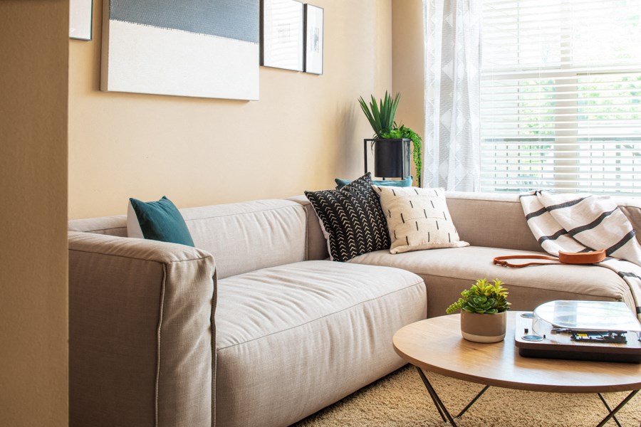 A living room with a beige couch and a coffee table.