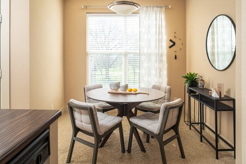 A dining room with a round table and chairs.