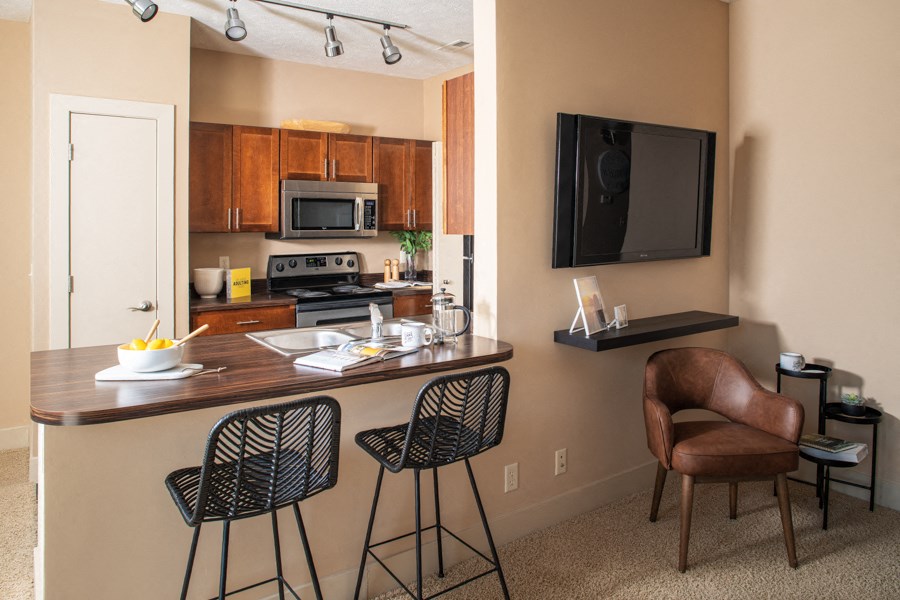 A kitchen with a bar area and a television.