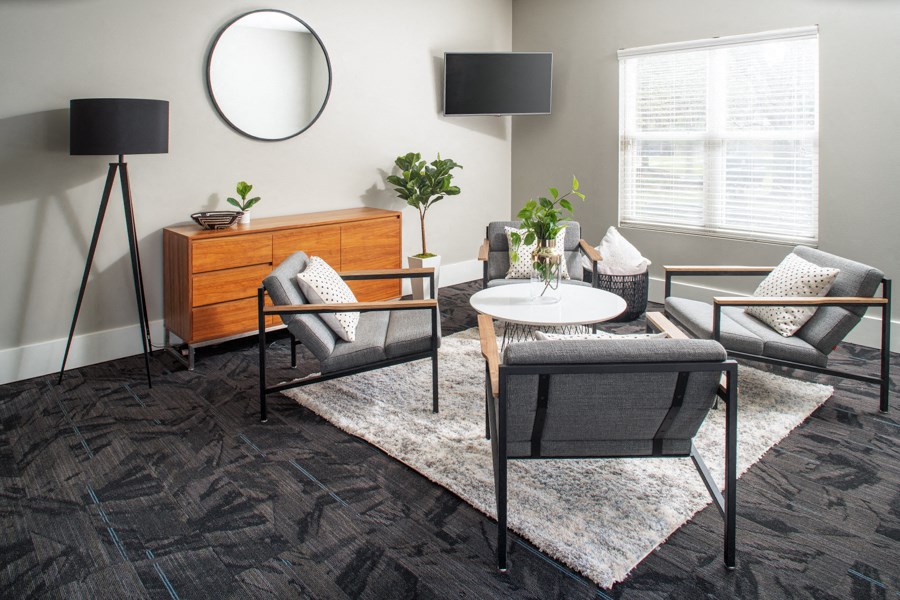 A modern living room with a grey sofa, a white coffee table, and a black floor lamp.