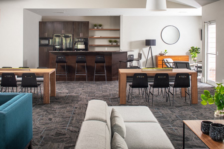 A modern living room with a kitchen area in the background.