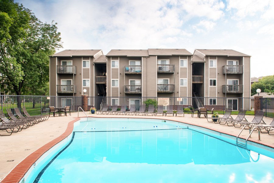 A large swimming pool in front of apartment buildings.