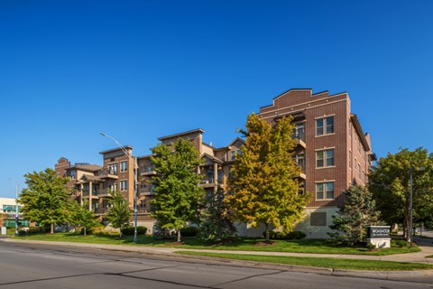 A large apartment building with a green lawn in front.