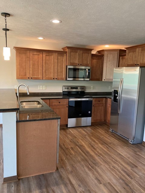 a kitchen with wooden cabinets and stainless steel appliances
