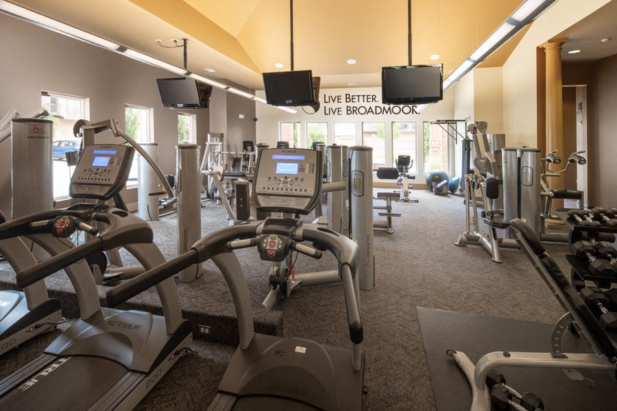 a gym with various cardio machines and weights