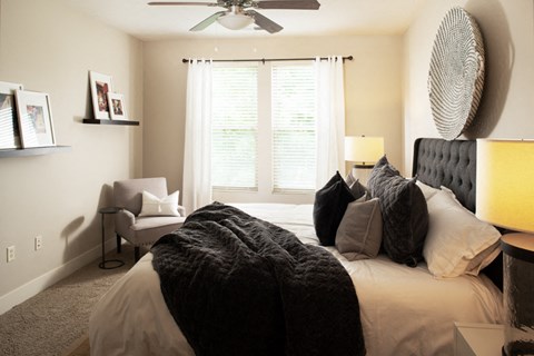 a bedroom with a large bed and a ceiling fan