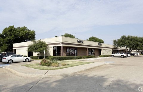 A building with a parking lot in front of it.
