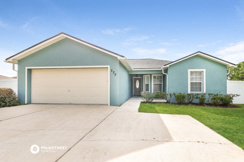 a blue house with a driveway and a garage door