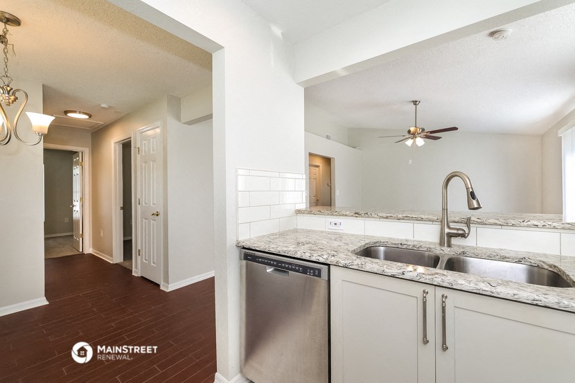 a kitchen with white cabinets and a stainless steel dishwasher