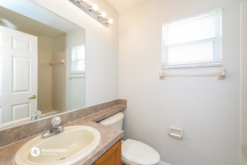 a bathroom with a toilet and a sink and a mirror