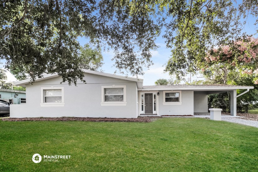 a white house with a lawn and trees