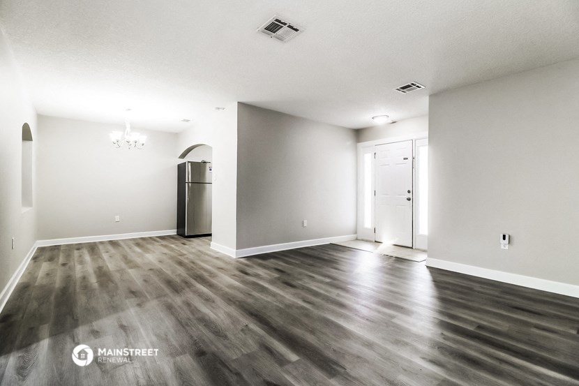 an empty living room with white walls and wood floors