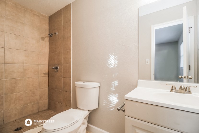 a bathroom with a toilet and a sink and a mirror