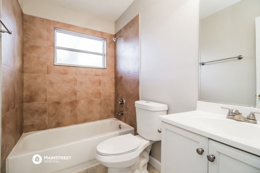 a bathroom with a toilet and a tub and a sink