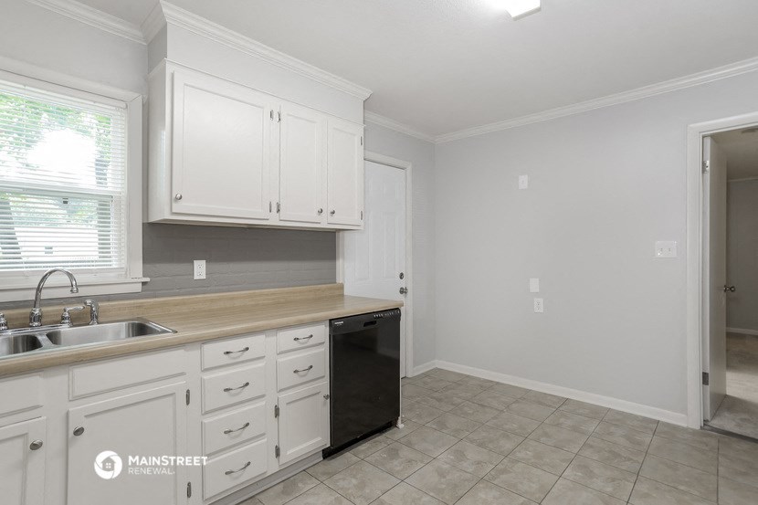 a kitchen with white cabinets and a sink and a dishwasher