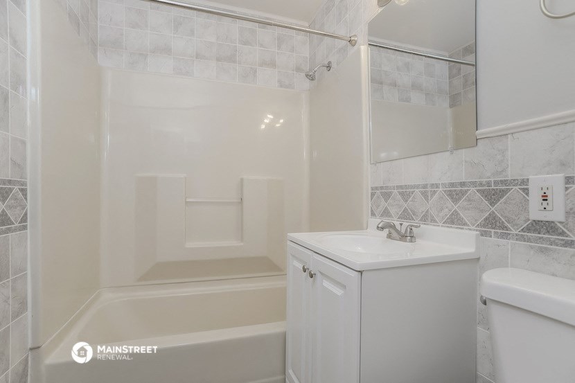 a white bathroom with a sink and a bath tub