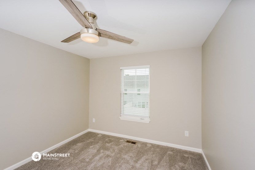 a bedroom with a ceiling fan and a window