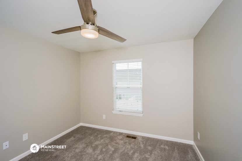 a bedroom with carpet and a ceiling fan