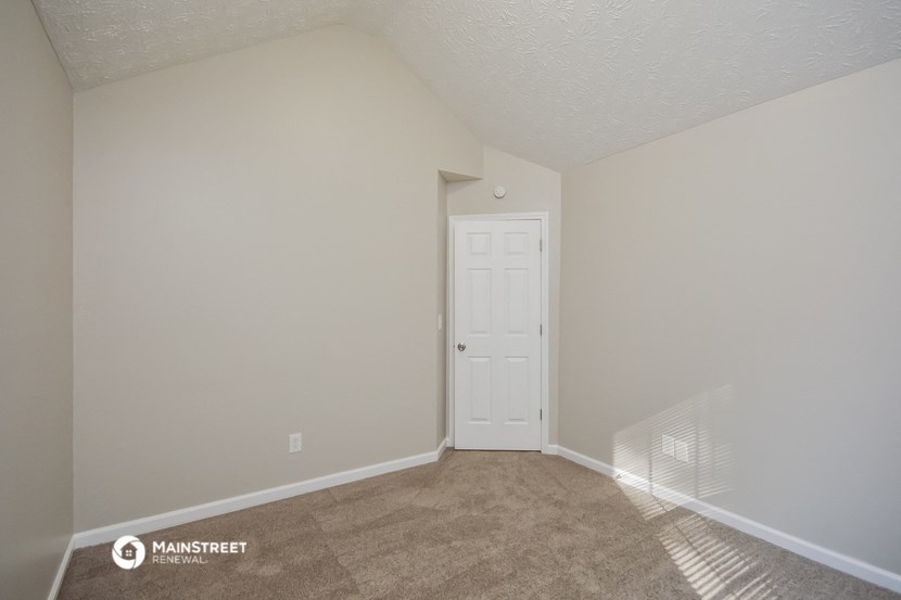the spacious living room with a door to the closet