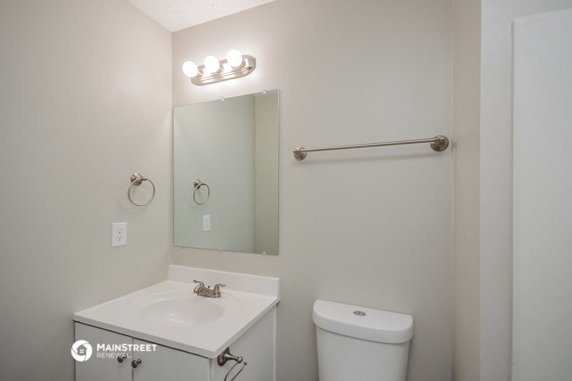 a bathroom with a sink and a mirror and a toilet
