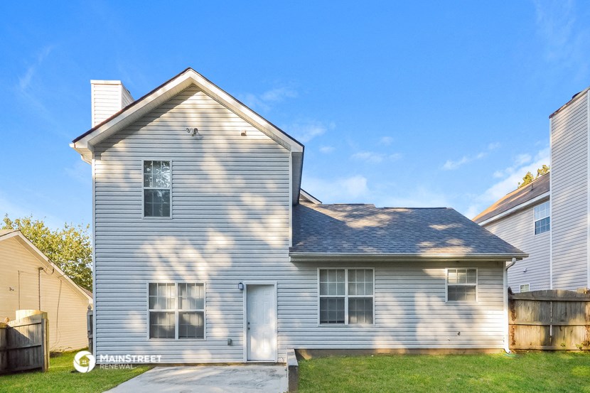 a white house with a gray roof and a driveway