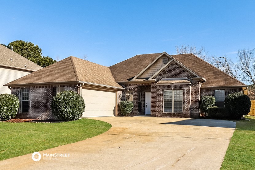 a brick house with a driveway and a white garage door