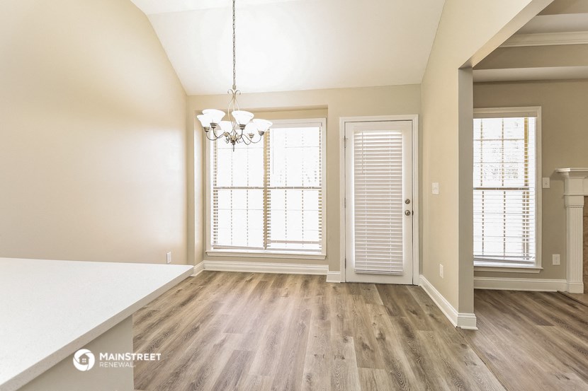 an empty living room with a window and a door