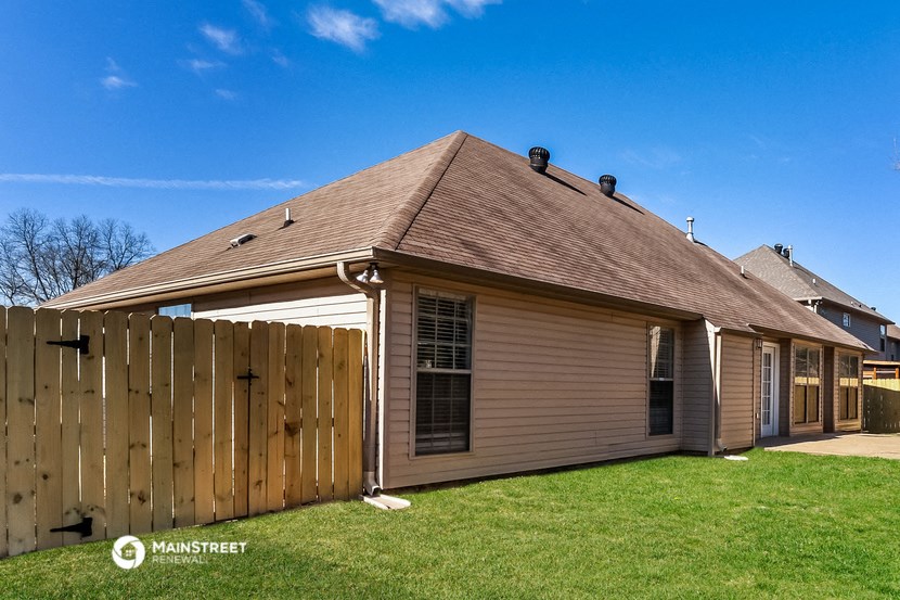 a backyard with a house and a wooden fence
