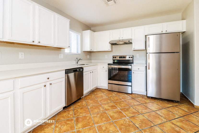a kitchen with white cabinets and stainless steel appliances