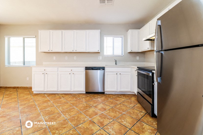 an empty kitchen with stainless steel appliances and white cabinets