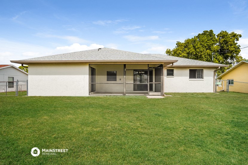 a small white house with a grassy yard