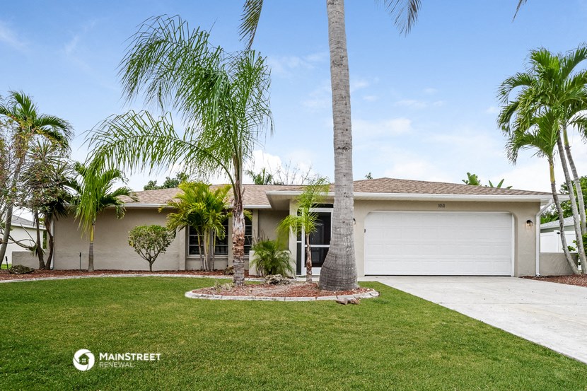 a white house with palm trees in front of it