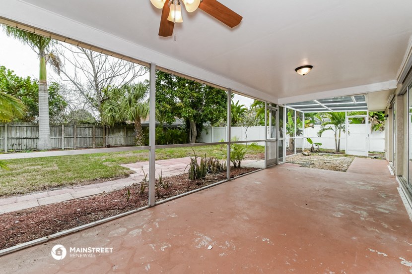a patio with glass doors and a yard in the background