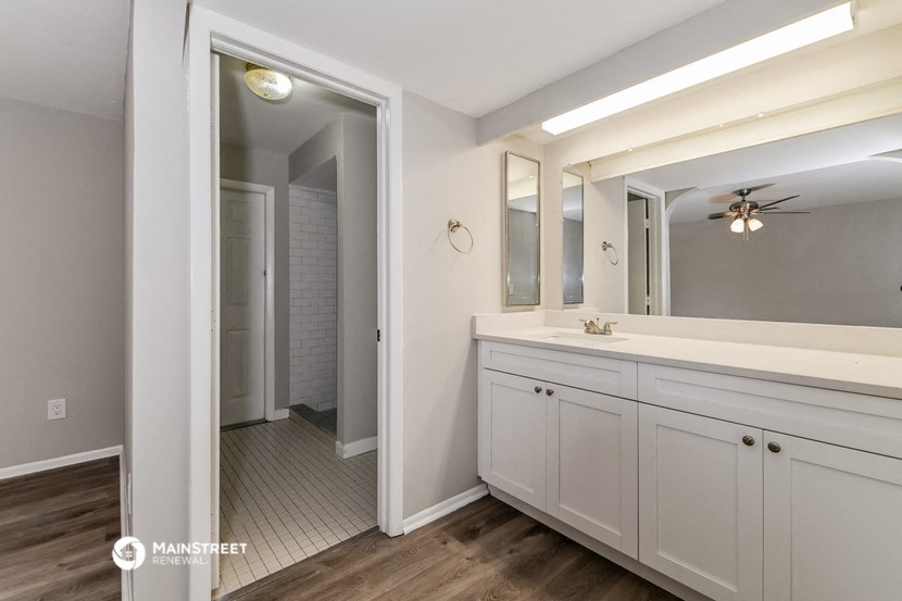 a white bathroom with a large mirror and a large sink
