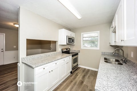 the kitchen of our studio apartment atrium with granite counter tops and white cabinets