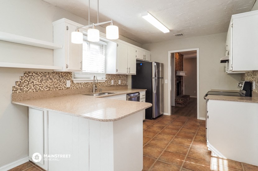 a kitchen with white cabinets and a counter top