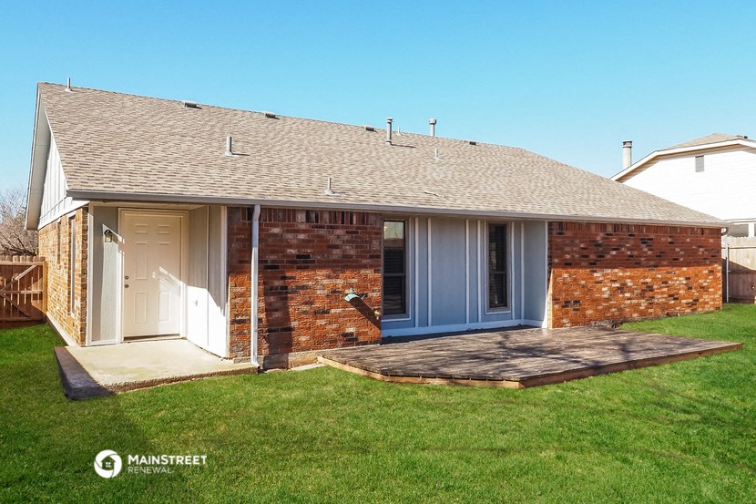 a small brick house with a porch and a blue door