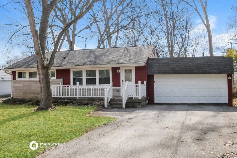 a red house with a garage and a white fence