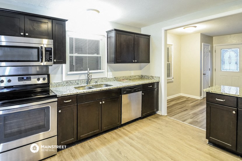 a kitchen with black cabinets and stainless steel appliances